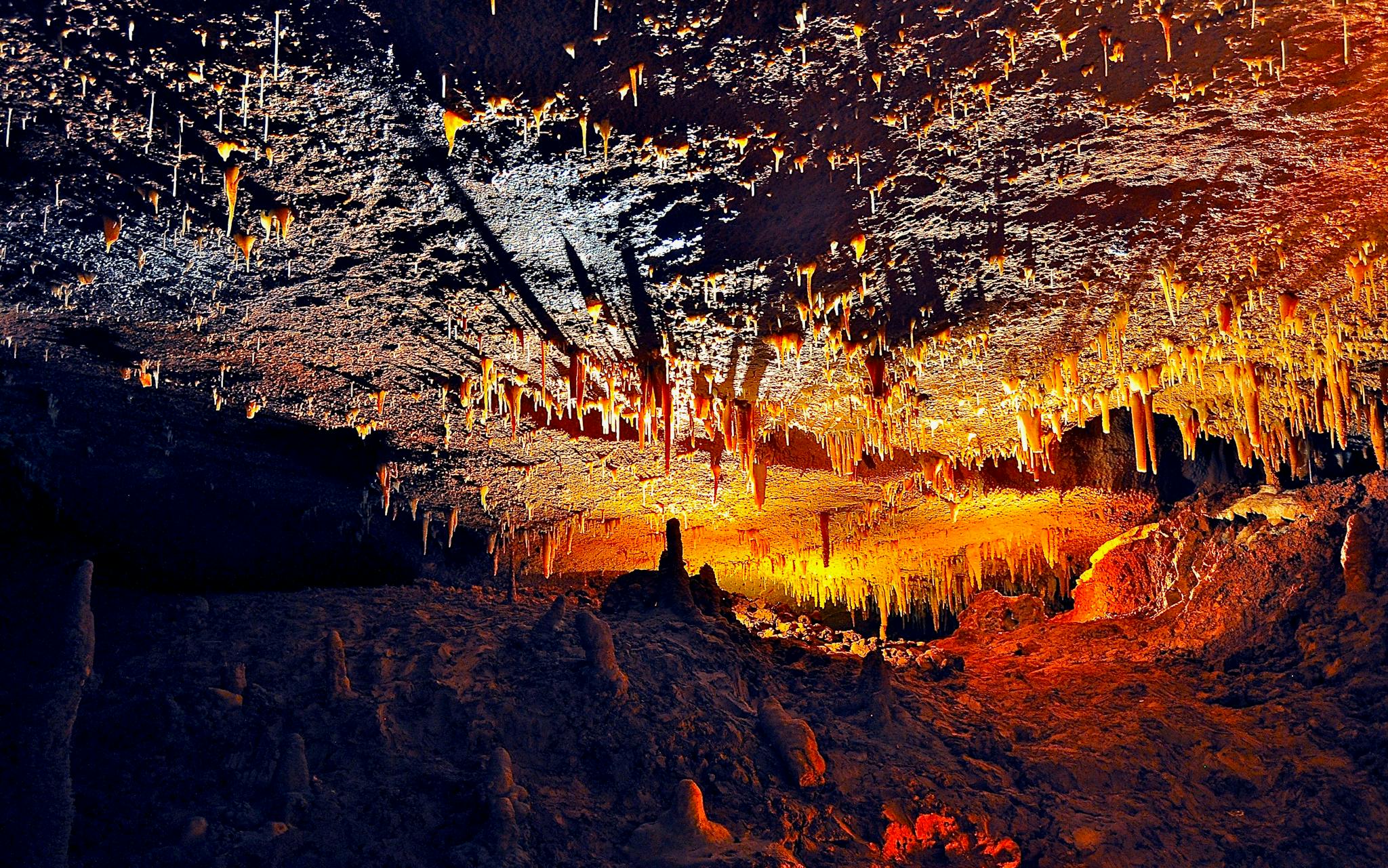 Explore the vibrant colors and unique formations of a stalactite-filled cave, captured in stunning detail.